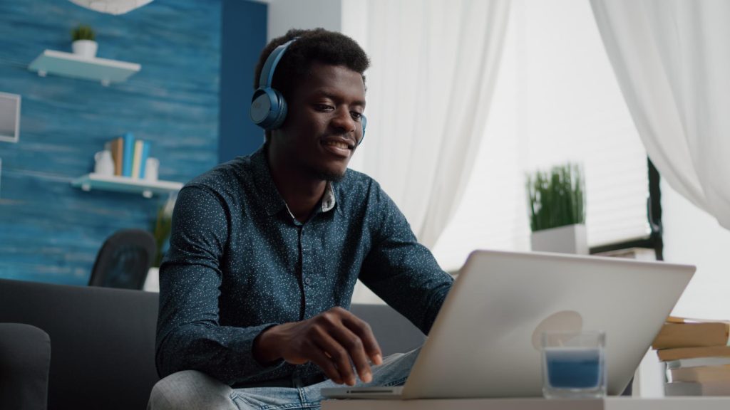 Young man with headphones looking at laptop