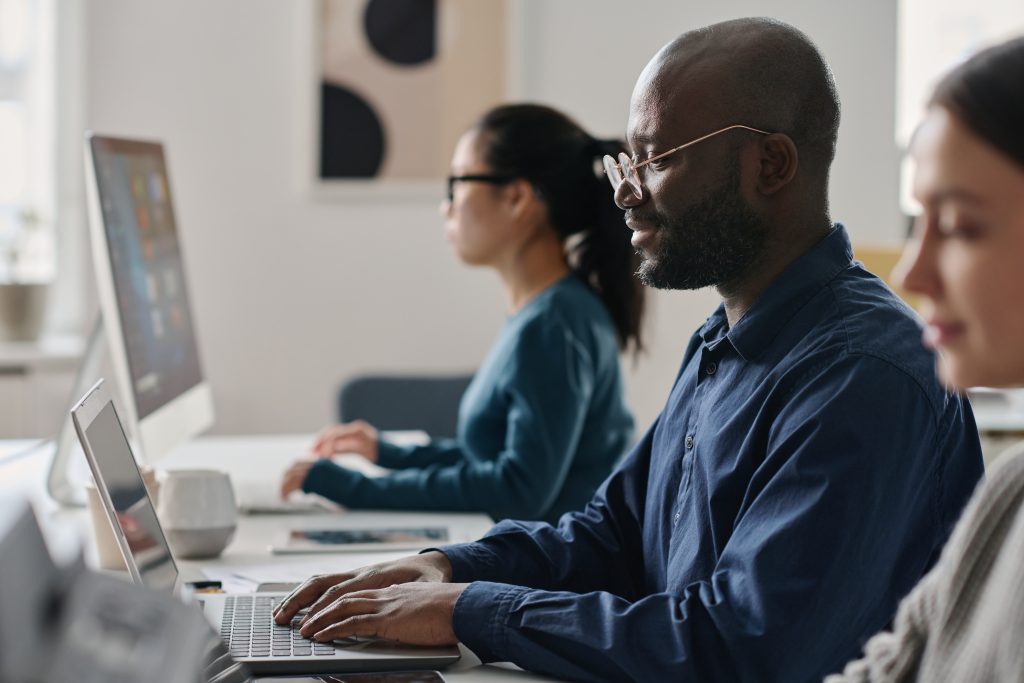 ethnically diverse managers working on computers in office