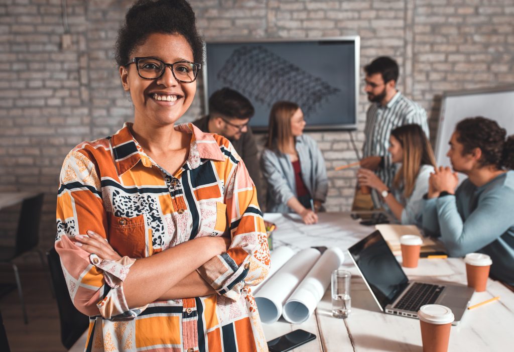 portrait of young female leader standing in office looking at ca